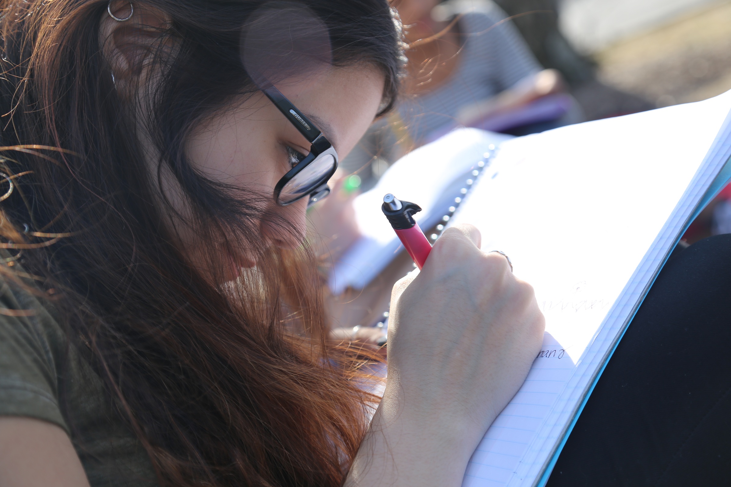 Closeup of teen writing in a notebook